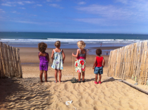 4 children on the beach looking at the sea