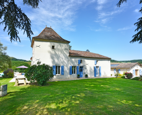 Manoir and Gite Holiday Rental view of White painted French Manoir with blue shutters and Pigionnier Tower